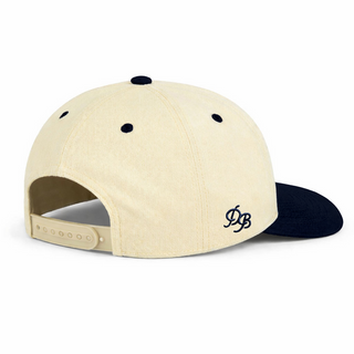 Dad Brand Dad snapback hat in cream and black, shown from side view, featuring a classic design and adjustable strap.