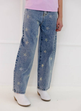 Lola and The Boys Crystal Stars Jeans Person wearing blue jeans with star patterns and white boots on a white background