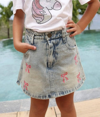 Lola & the Boys Cutie Bows denim skirt with bow accents, casual style, front pockets, and adjustable waistband.