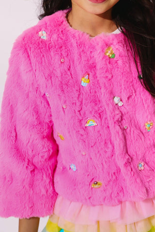 Lola and The Boys Cutie Charms Faux Fur Jacket
Close-up of a pink fluffy jacket with colorful patches on a plain background