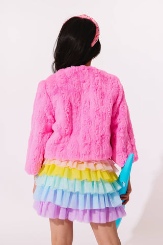 Lola and The Boys Cutie Charms Faux Fur Jacket
Person wearing a pink fluffy jacket and colorful skirt holding a blue object against a white background