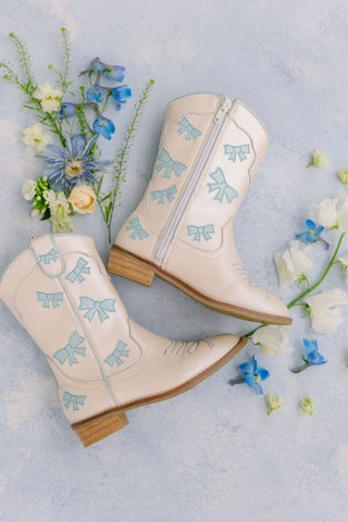 Baby blue cowgirl boots by Wild & Rae with bow detail, showcasing stylish Western footwear for young girls.