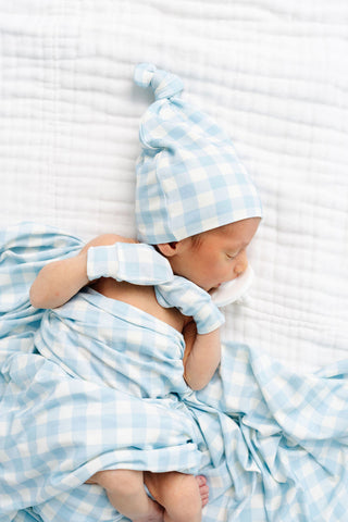 Lou Lou and Company Knit Top Knot Hat - Walker
Newborn baby swaddled in blue and white checkered blanket with matching hat.