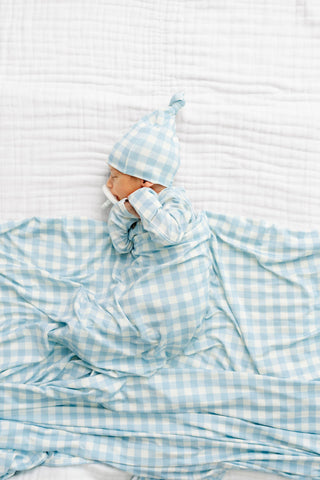 Lou Lou and Company Knit Top and Bottoms - Walker
Baby wrapped in a blue checkered blanket with a matching hat on a white background