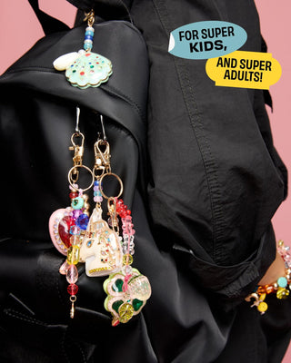Super Smalls Super Unicorn Bag Charm
Colorful earrings hanging from a black jacket with text 'For Super Kids, and Super Adults!' on a pink background.