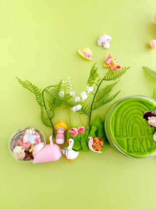 EGKD  Earth Grown KidDoughs Garden KidDough Play Kit 
Decorative set with small figurines, plants, and a container labeled 'Ecko' on a green background