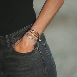 K'lani "Ember" with Tortoise Shell Ring Charm Hair Tie Bracelets
Person wearing multiple bracelets on a blurred background