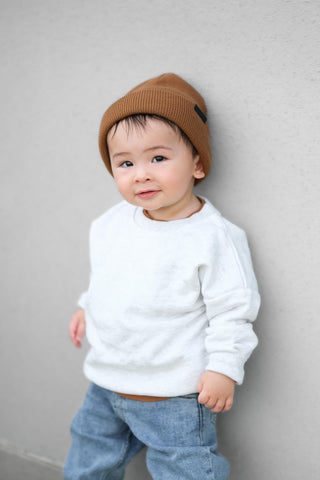 Little Bipsy Chunky Knit Beanie - Chestnut
Child wearing a white sweater and brown beanie against a plain background