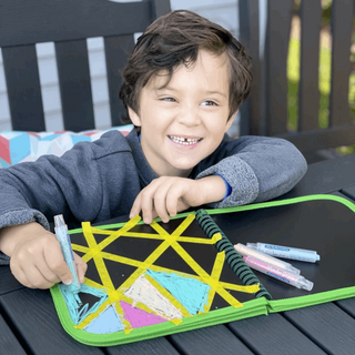Daily Doodler Reusable Activity Book - Dino Cover
Child drawing on a colorful art kit with markers outdoors.