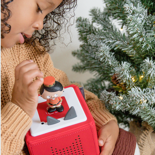 Tonies Character - Favorite Masterpieces: The Nutcracker
Child playing with a red toy device featuring a character near a Christmas tree.
