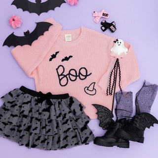 Sweet Wink Boo Bat Halloween Knit Sweater
Sweet Wink Flocked Bats Halloween Bow Tiered Tutu 
Pink sweater with 'BOO' text, gray skirt with bat pattern, black boots, and Halloween accessories on a purple background.