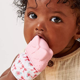 Itzy Ritzy Teething Mitt - Bow
Baby holding a pink teething ring with floral sleeve