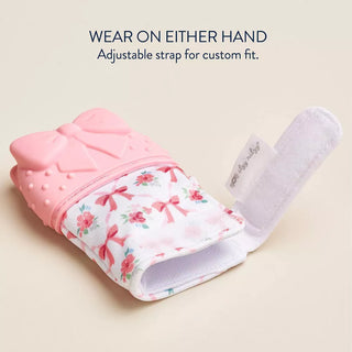 Itzy Ritzy Teething Mitt - Bow
Pink glove with floral pattern and adjustable strap on a beige background