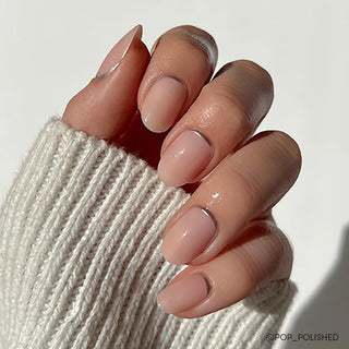 Glamnetic Press-On Nails Short Round - Silver Belle
Close-up of a hand with nude nail polish wearing a beige sweater.