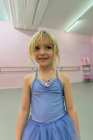 Great Pretenders Moonlight Necklace
Young girl in a blue dress posing in a dance studio.