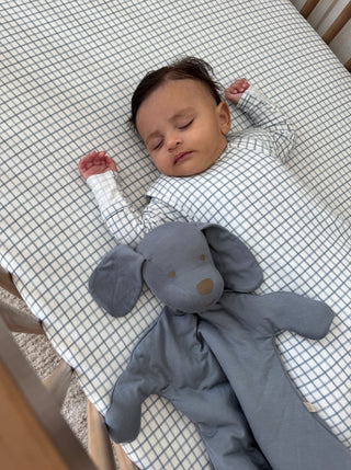 Gunamuna Pup Lovey - Dusky
Baby lying on a crib with a gray elephant toy