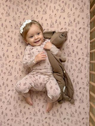Gunamuna Pup Lovey - Peanut
Child in a patterned outfit holding a plush toy on a matching background