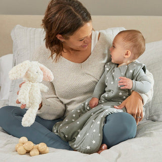 Gunamuna Sleep Sack 2.5 TOG - Shine
Woman holding a baby and a plush toy on a bed