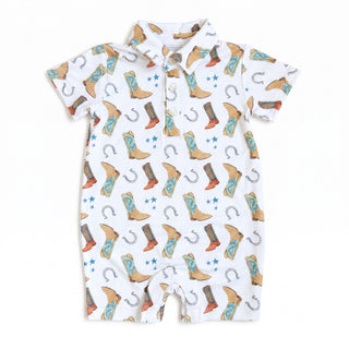 Hollis Baker Knox Romper - Boots: Blue
A baby short-sleeve romper with a white base and an all-over western print featuring cowboy boots, horseshoes, stars, and buckles, displayed flat against a white background.