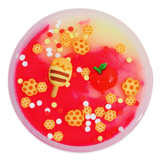 Peachybbies Icee Slime - Honey Crisp Apple
A round, translucent plastic container filled with bright red and pale yellow gel or slime, decorated with small honeycomb pieces, white and red confetti, a honey dipper charm, and a red apple charm, set against a plain white background.