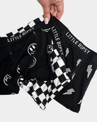 Little Bipsy Boxer Brief 3 Pack - Smiley / Checkered / Lightening Bolt
Black underwear with various patterns and 'LITTLE BIPSY' branding held by a hand.