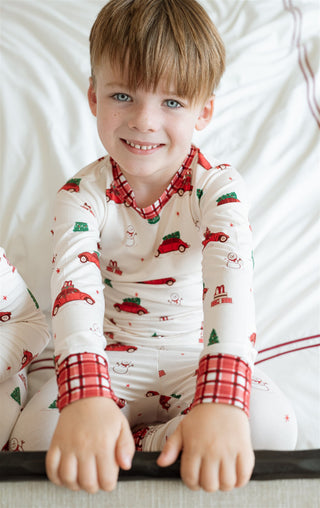 In My Jammers Red Holly Jolly Cruisers Two Piece Set
Child wearing a red and white pajama set with car pattern on a white background