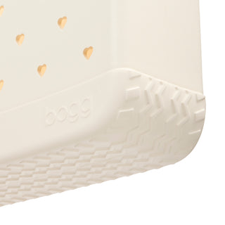 In Love BABY BOGG BAG Coconut
Close-up of a cream-colored Bogg pet crate corner, showing the embossed brand name and textured rubber base with heart-shaped ventilation holes.