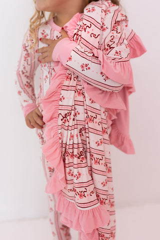 In My Jammers Ruffle Blanket - Vintage Love
Child wearing a pink floral dress with ruffles on a white background