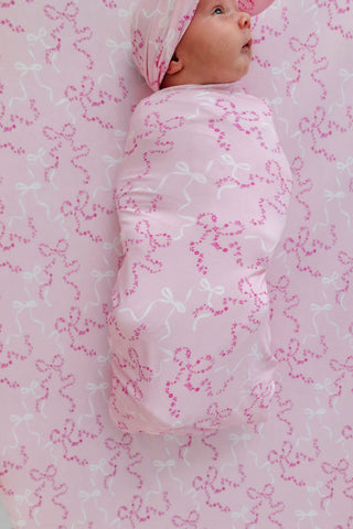 In My Jammers Swaddle Blanket - Cora Floral Bows
Baby swaddled in a pink blanket with bow pattern on a matching background