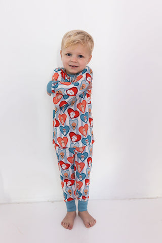 In My Jammers Two Piece Set - Blue Fur-Ever Valentine
Child wearing a colorful heart-patterned onesie on a white background