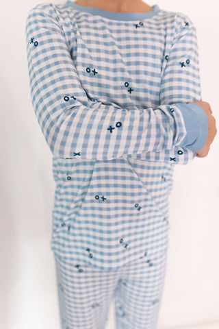 In My Jammers Two Piece Set - Blue XO Gingham
Children's blue checkered pajama set with star patterns on a white background