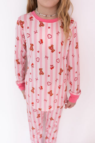 In My Jammers Two Piece Set - Love You Bear-y Much
Child wearing pink pajamas with teddy bear and heart patterns on a white background