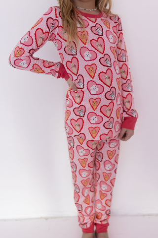 In My Jammers Two Piece Set - Pink Fur-Ever Valentine
Child wearing a pink heart-patterned onesie on a white background