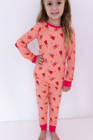 In My Jammers Two Piece Set - Pink Sugar Rush
Child wearing a pink pajama set with heart patterns on a white background