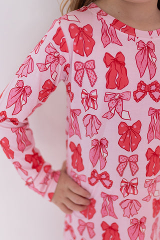 In My Jammers Two Piece Set - Valentine's Bows
Pink dress with red bow pattern worn by a person