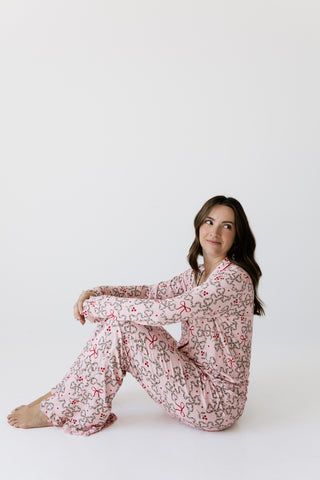 In My Jammers Women's Long Sleeve Ruffle Set - Mistletoe Bows
A woman sitting cross-legged on a white studio floor wearing a long-sleeve pajama set with a pink and gray floral pattern.