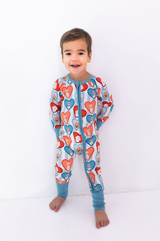 In My Jammers Zipper Romper - Blue Fur-Ever Valentine
Child wearing a colorful heart-patterned onesie on a white background