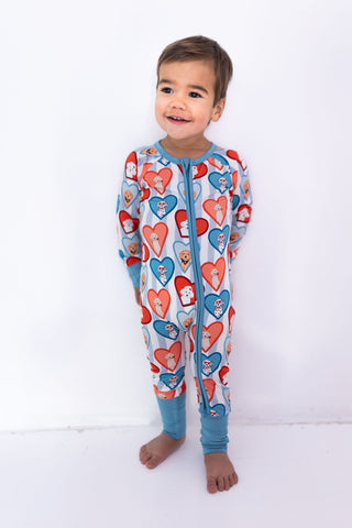 In My Jammers Zipper Romper - Blue Fur-Ever Valentine
Child wearing a colorful heart-patterned onesie on a white background