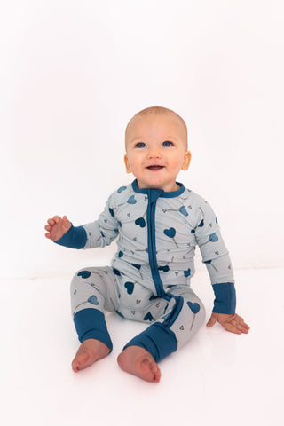 In My Jammers Zipper Romper - Blue Sugar Rush
Baby wearing a blue and gray onesie with heart patterns on a white background