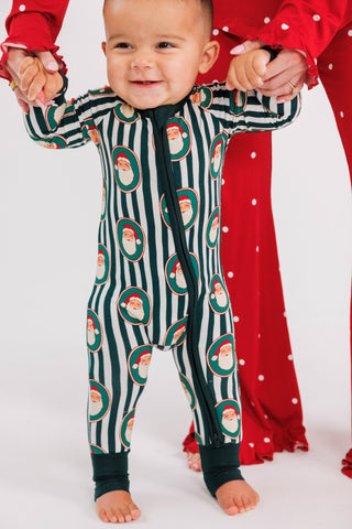 In My Jammers Green Santa Claus Lane zipper romper pajamas displayed on a model, featuring festive holiday-themed print.