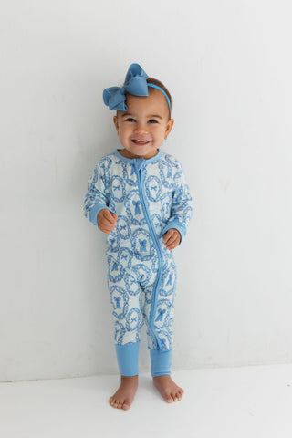 In My Jammers Zipper Romper - Julia Bow
Baby wearing a blue and white patterned onesie with a matching headband against a white background