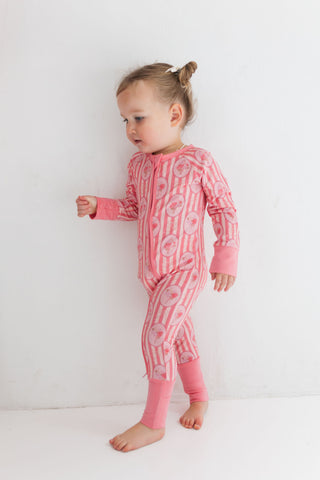 In My Jammers Zipper Romper - Pink Blaire
Child wearing a pink onesie with patterns on a white background