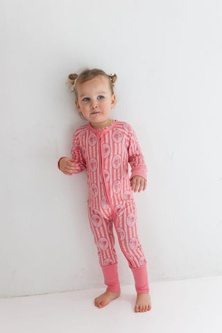 In My Jammers Zipper Romper - Pink Blaire 
Child wearing a pink patterned onesie against a white background