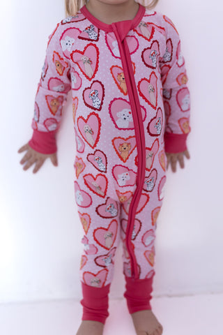 In My Jammers Zipper Romper - Pink Fur-Ever Valentine
Child wearing a pink heart-patterned onesie with a zipper on a white background