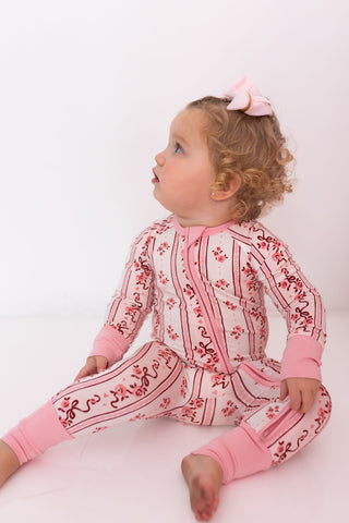 In My Jammers Zipper Romper - Vintage Love
Child wearing a pink and white patterned outfit on a white background