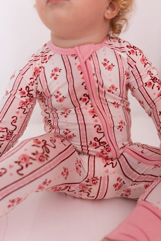 In My Jammers Zipper Romper - Vintage Love
Child wearing a pink floral outfit on a white background