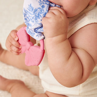 Itzy Ritzy Crinkle Crew™ bow teether with soft fabric and crinkle sound, designed for babies to chew and soothe teething discomfort.