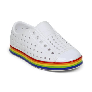 Native Jefferson Wrapped Shoes - Shell White / Rainbow
A white perforated slip-on shoe with a glossy finish and a colorful rainbow stripe along the side, shown on a plain white background.