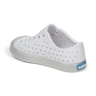 Native Jefferson Wrapped Shoes - Shell White / Hologram
A white slip-on clog shoe with perforated holes on the upper, a gray sole, and a blue 'native' brand tag on the heel, shown from a side-rear angle on a white background.