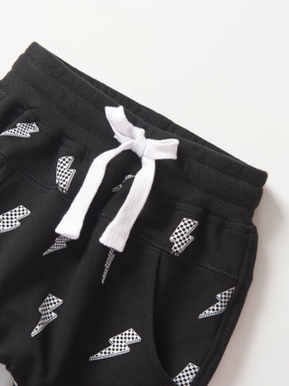 Little Bipsy Lightning Bolt Jogger - Black
Black shorts with white checkered patterns and drawstring on a light gray background